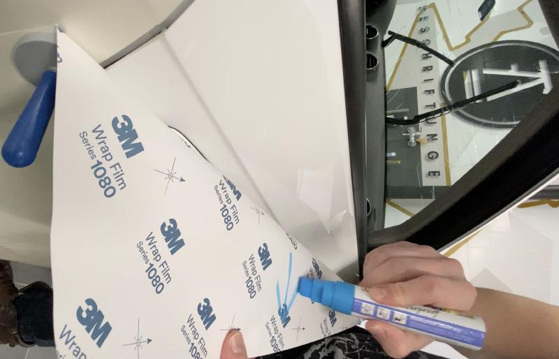 Profi-Folierer markiert Wrap Film vor dem Zuschnitt