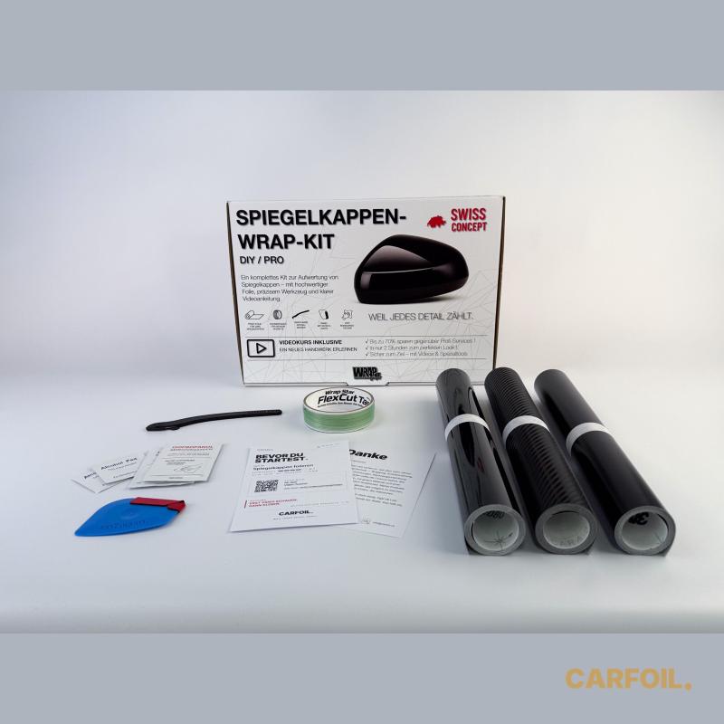 DIY-WrapKit Spiegelkappen folieren von carfoil.ch — Box mit drei Folienrollen (Schwarz Glanz, Carbon, Schwarz Satin), Schneidfaden, Rakel mit Filz, IPA-Reinigungstüchern und Anleitungs-Karte mit QR-Code zum Video-Kurs.